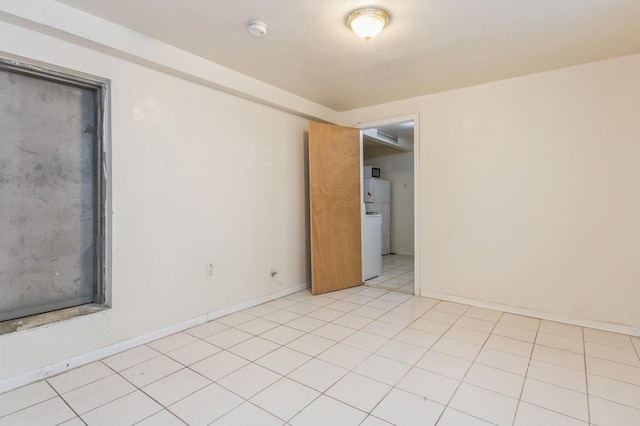 spare room with light tile patterned floors and baseboards