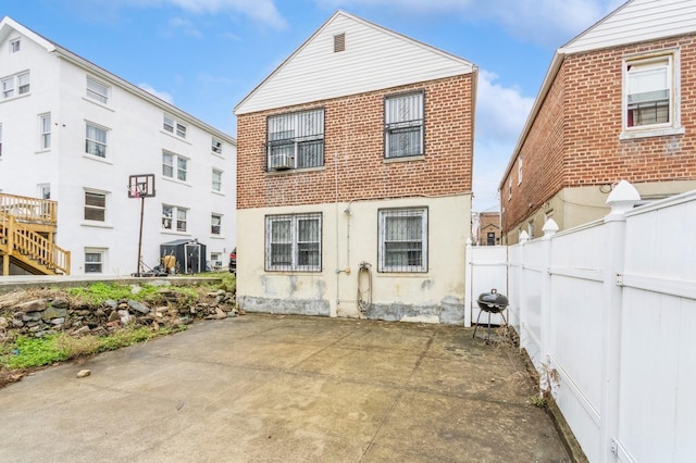 back of property with fence and a patio