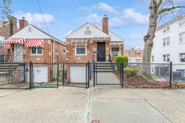 view of front of home featuring an attached garage, a chimney, a fenced front yard, and a gate