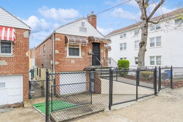 view of front of property featuring brick siding, fence, and a gate