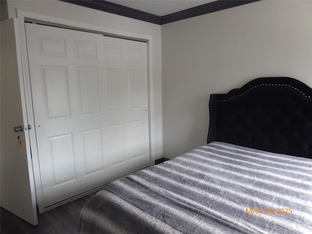 bedroom with crown molding, a closet, and dark wood-style floors