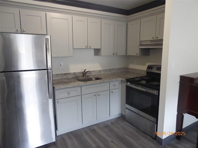 kitchen with light stone counters, dark wood-style floors, under cabinet range hood, stainless steel appliances, and a sink