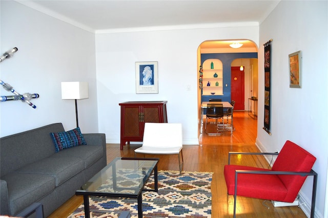 living area featuring arched walkways and hardwood / wood-style floors
