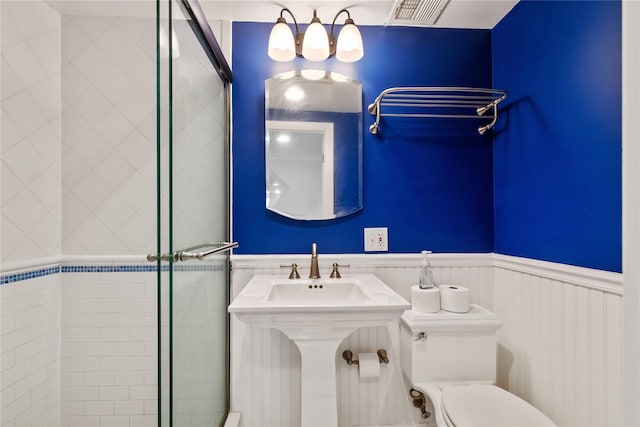 bathroom featuring a shower stall, visible vents, and wainscoting