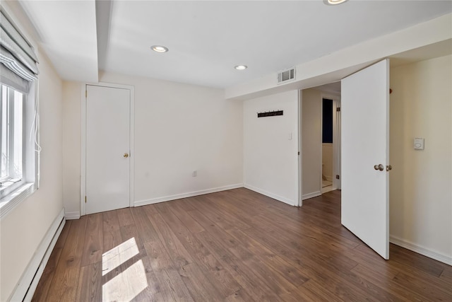 spare room with plenty of natural light, visible vents, recessed lighting, wood finished floors, and a baseboard radiator