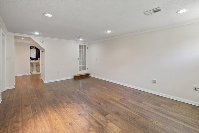 empty room with dark wood-style flooring, a textured ceiling, visible vents, and recessed lighting