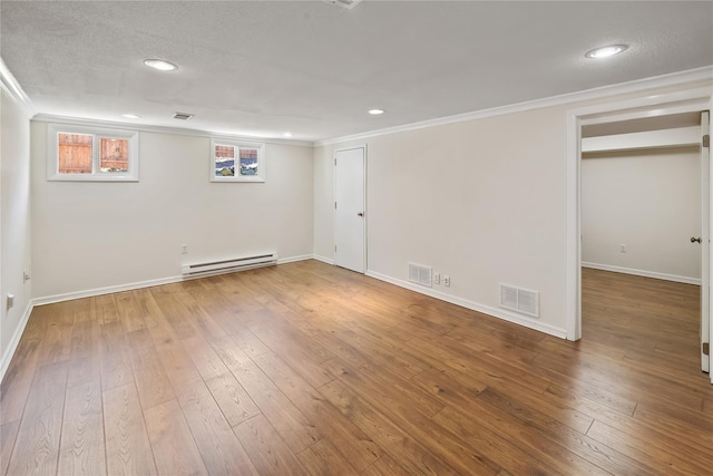basement featuring a baseboard radiator, visible vents, and ornamental molding