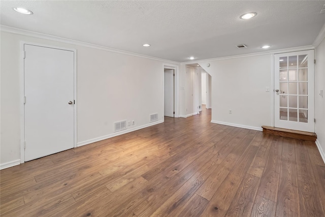 empty room with recessed lighting, visible vents, crown molding, and hardwood / wood-style flooring