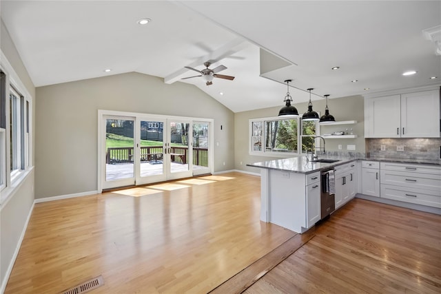 kitchen with white cabinets, a peninsula, a sink, a ceiling fan, and open shelves