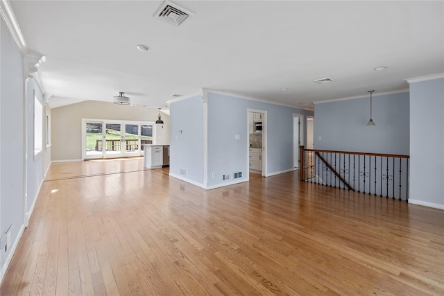 unfurnished living room with baseboards, light wood-style flooring, visible vents, and crown molding