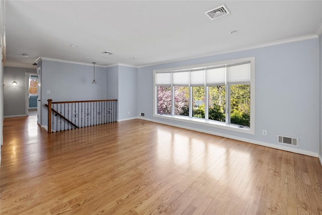 empty room with light wood finished floors, baseboards, and visible vents
