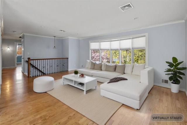 living room with wood finished floors, visible vents, and ornamental molding