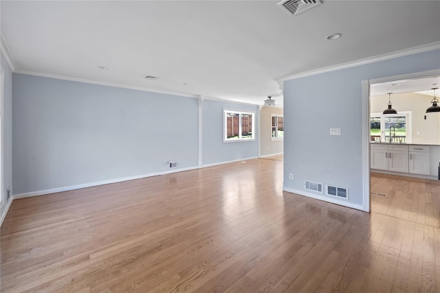 unfurnished living room featuring light wood-type flooring, visible vents, and crown molding