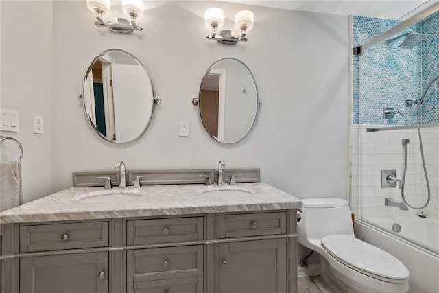 full bathroom with shower / bath combination with glass door, a sink, double vanity, and toilet