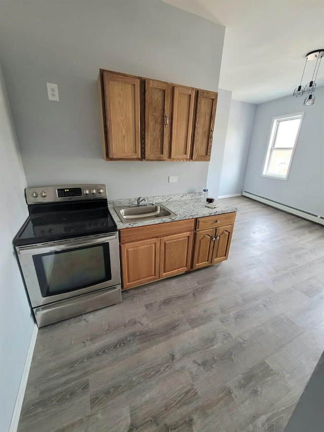kitchen with baseboard heating, brown cabinets, stainless steel electric range oven, and a sink