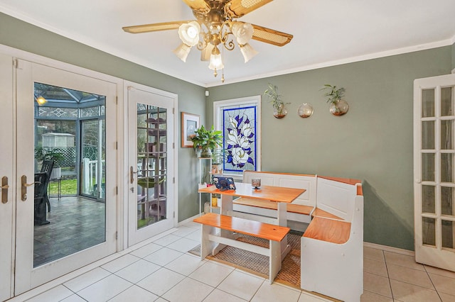 dining area with crown molding, light tile patterned floors, baseboards, and a ceiling fan
