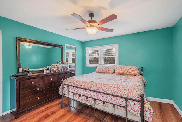 bedroom with baseboards, a ceiling fan, and wood finished floors