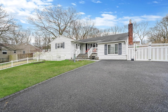 ranch-style home featuring a chimney, fence private yard, and a front yard