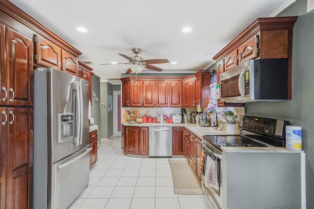 kitchen with stainless steel appliances, a sink, ceiling fan, light countertops, and light tile patterned floors