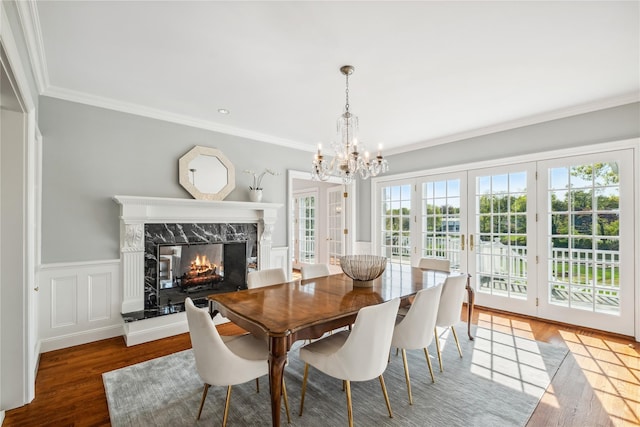 32 Pryer Ln, Larchmont, NY 10538 - dining area with ornamental molding, wainscoting, wood finished floors, a high end fireplace, and a chandelier