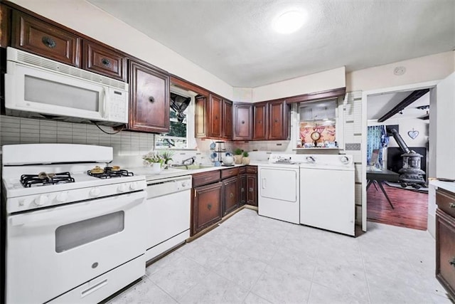 66-68 Spook Hole Rd, Ellenville, NY 12428 - kitchen with white appliances, dark brown cabinetry, separate washer and dryer, light countertops, and decorative backsplash