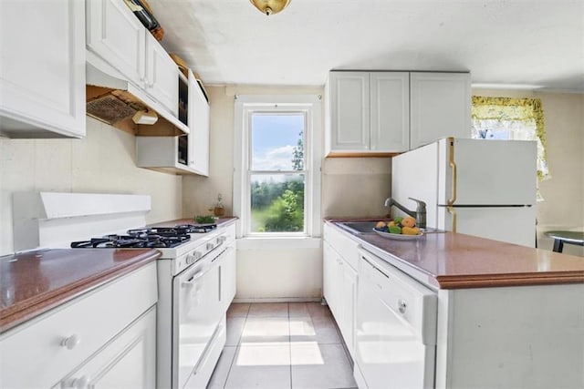 66-68 Spook Hole Rd, Ellenville, NY 12428 - kitchen featuring white appliances, light tile patterned flooring, white cabinets, under cabinet range hood, and a sink
