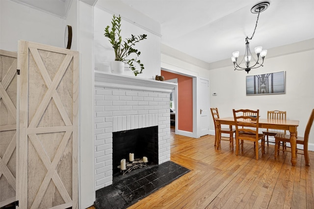 155 Tuckers Corners Rd, Plattekill, NY 12528 - dining space with wood-type flooring, a chandelier, and a fireplace