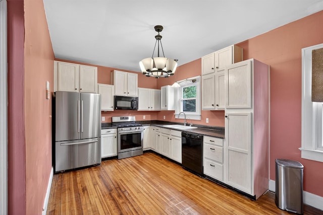 155 Tuckers Corners Rd, Plattekill, NY 12528 - kitchen featuring black appliances, dark countertops, a chandelier, light wood-style flooring, and pendant lighting