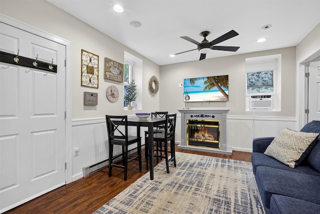 155 Tuckers Corners Rd, Plattekill, NY 12528 - living area featuring wood finished floors, ceiling fan, a glass covered fireplace, cooling unit, and a wainscoted wall