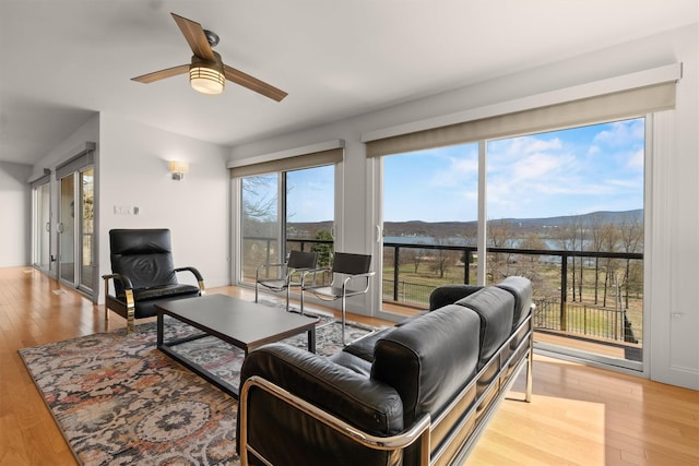 living room with a mountain view, a ceiling fan, and wood finished floors
