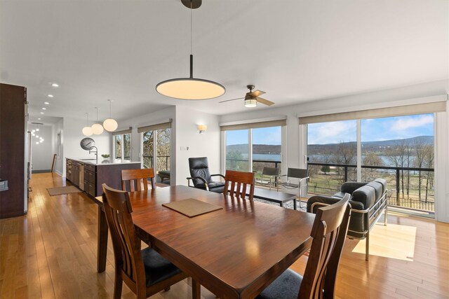 dining room with light wood-style flooring, a ceiling fan, and recessed lighting