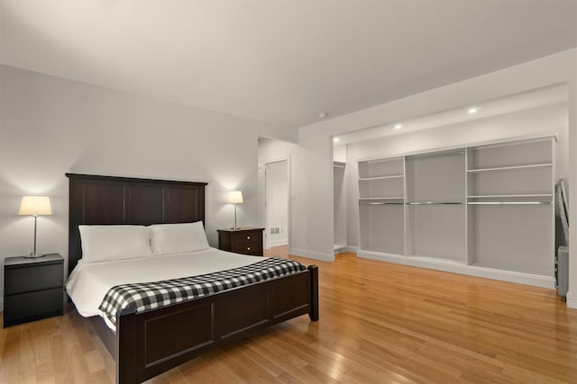 bedroom with light wood-style flooring, baseboards, and recessed lighting