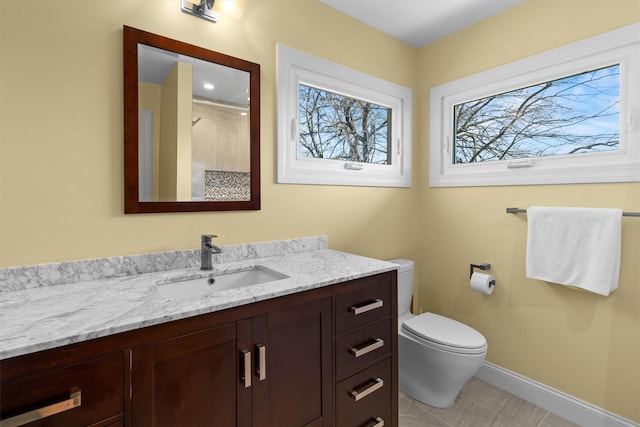 bathroom featuring vanity, baseboards, tile patterned floors, walk in shower, and toilet