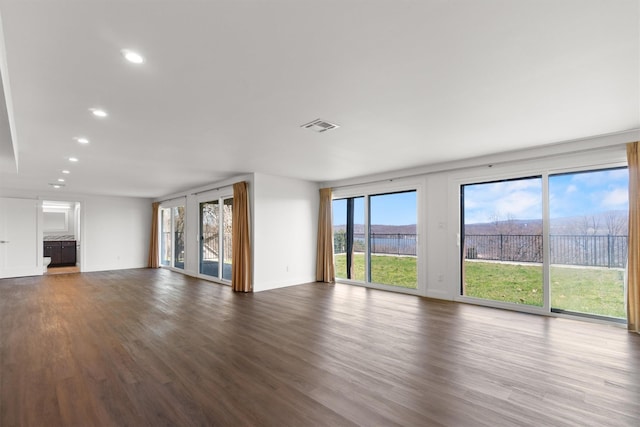 unfurnished living room with visible vents, recessed lighting, and dark wood-type flooring