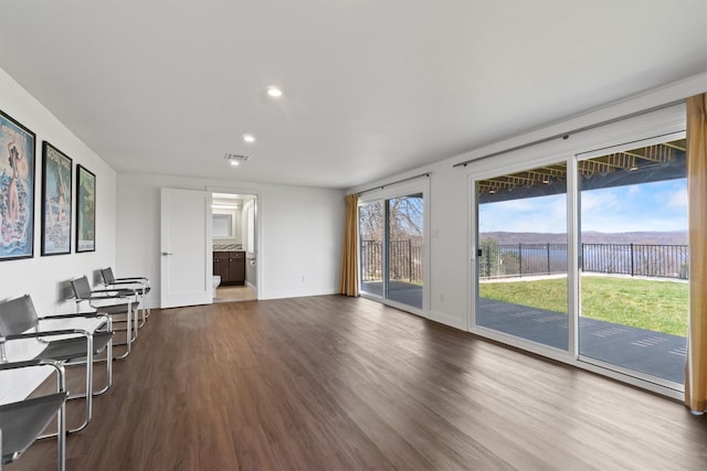 living area featuring wood finished floors, a water view, baseboards, visible vents, and recessed lighting