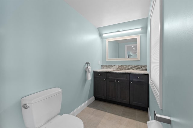 bathroom with toilet, tile patterned floors, vanity, and baseboards