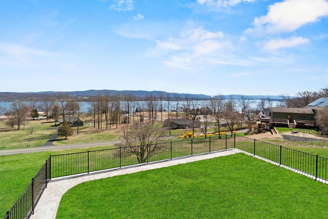 view of yard with a water and mountain view and fence