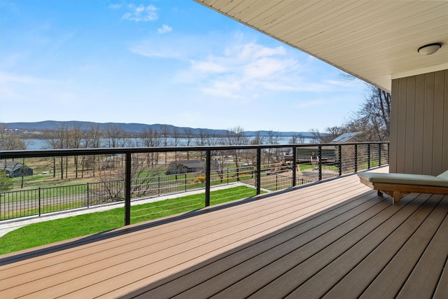 wooden terrace featuring a lawn, fence, and a mountain view