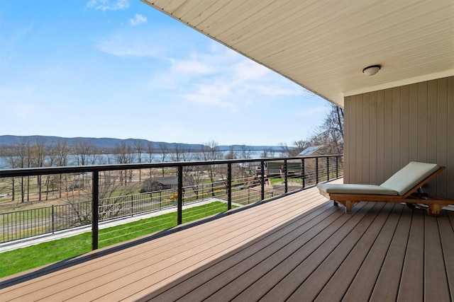 wooden deck with a mountain view and a lawn