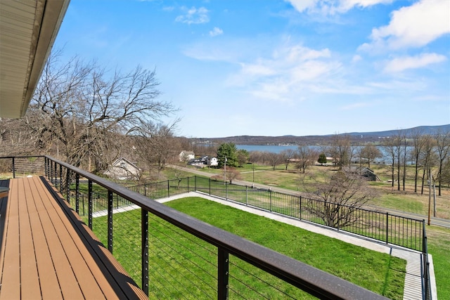 deck featuring fence, a lawn, and a water and mountain view