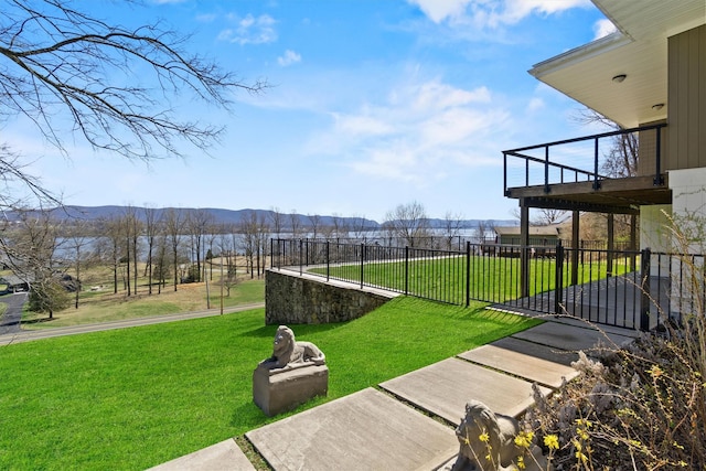 view of community with fence, a yard, and a mountain view