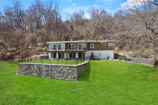 back of property with a lawn, fence, a deck, and stucco siding