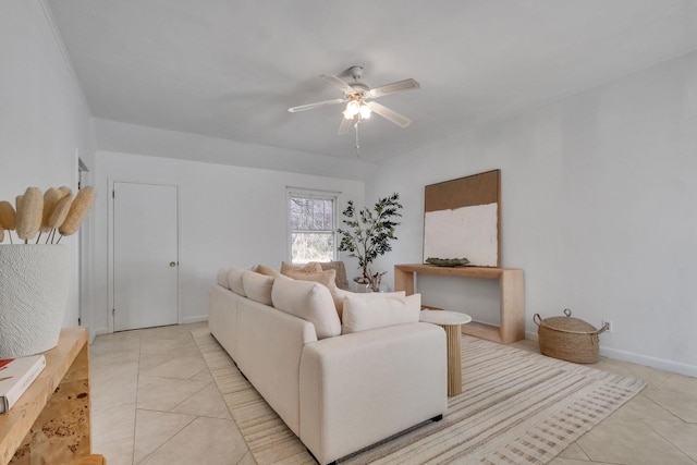 living area featuring light tile patterned floors, ceiling fan, and baseboards