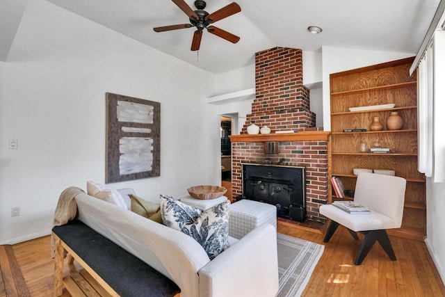 living room with baseboards, a brick fireplace, a ceiling fan, vaulted ceiling, and wood-type flooring