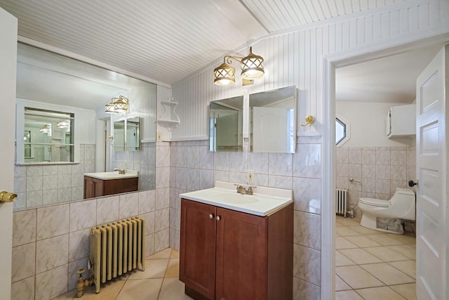 full bath featuring tile walls, radiator, tile patterned flooring, and vanity