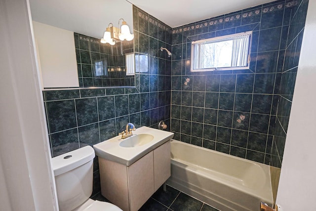 full bath with toilet, tile walls, vanity, tile patterned floors, and bathing tub / shower combination