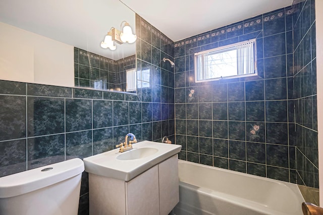 full bath featuring toilet, tile walls, shower / bath combination, and vanity