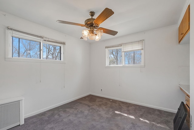 unfurnished room featuring radiator heating unit, carpet flooring, baseboards, and a ceiling fan
