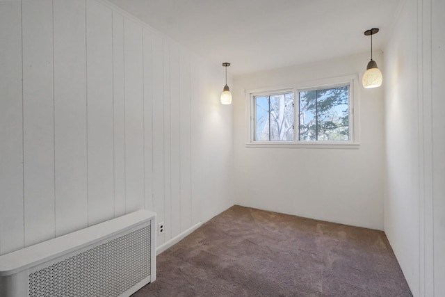 unfurnished room featuring dark carpet and radiator