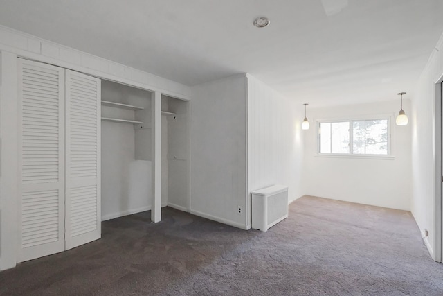 unfurnished bedroom featuring dark carpet and a closet